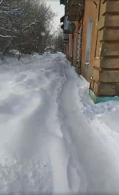 На неосвещенной улице Суздальской жители ходят по нечищенным тротуарам
